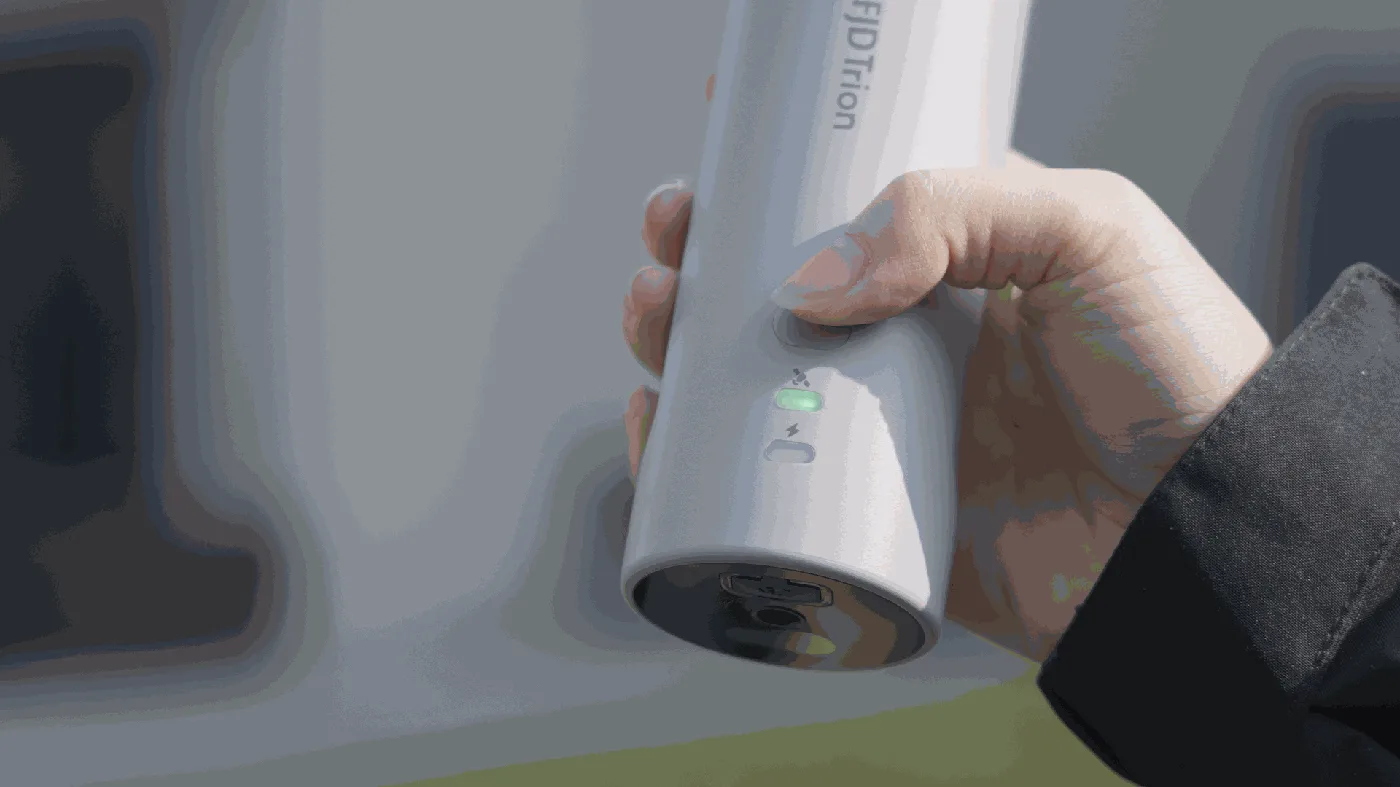 Hand som håller V4E Pro med en knapp och laseröppning