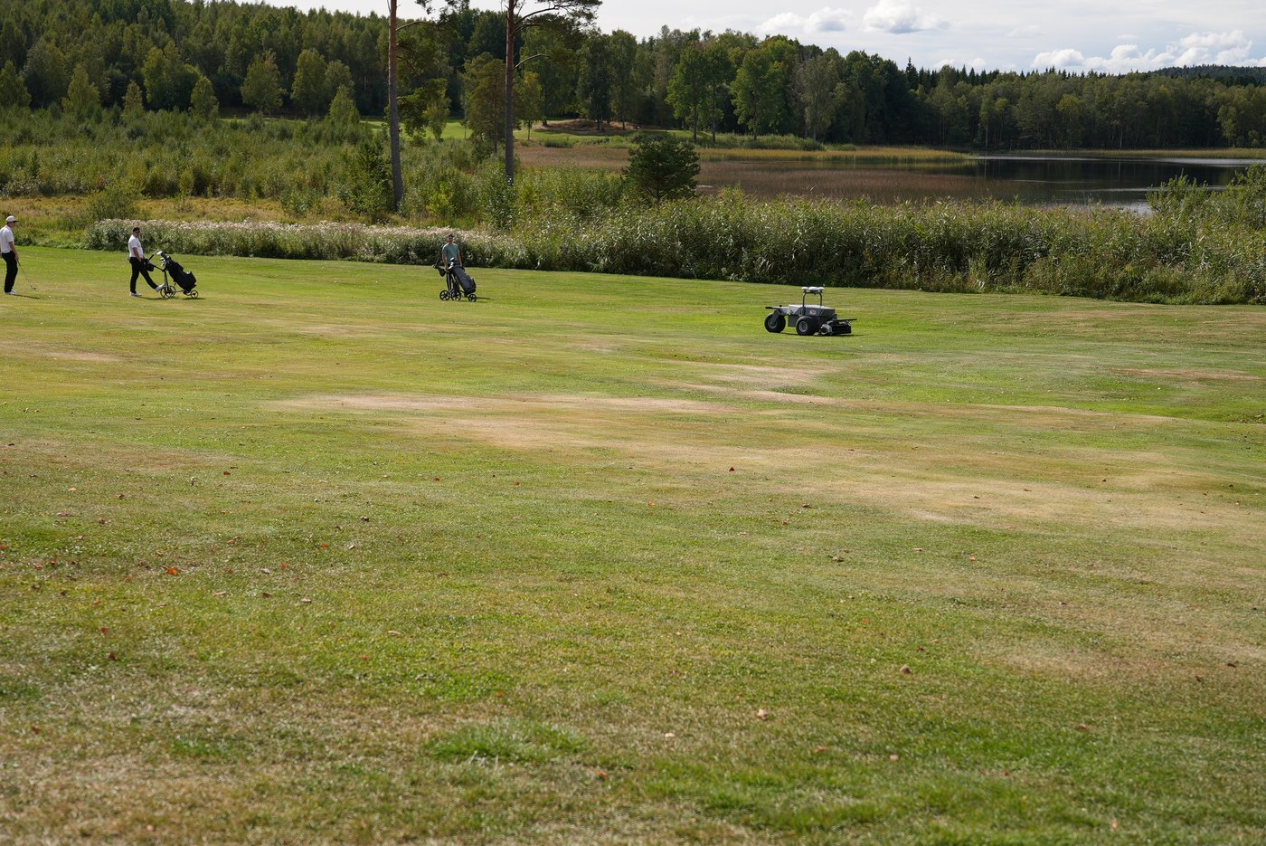 Spelare på banan medan FJD RCM01 klipper fairway på Hedemora Golfklubb