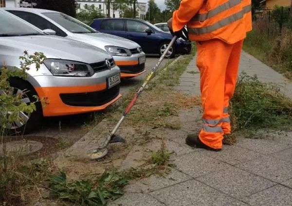IDECH Power Rotary Scissors in use - edge trimming near parked cars