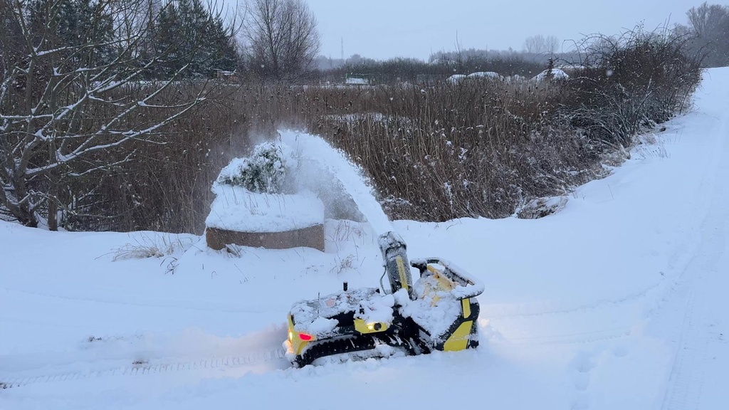 Nortec Explore X1 med snöslunga kastar snön i en stor båge vid en gårdsplan