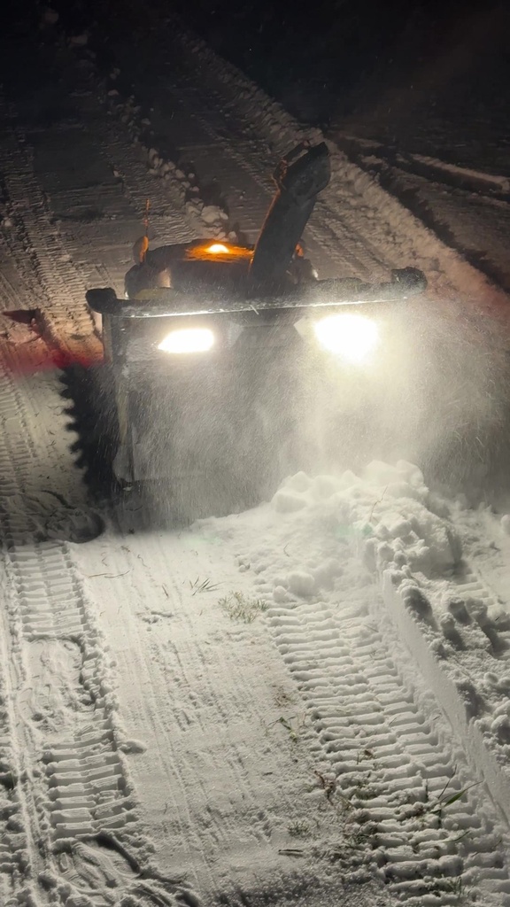 Nortec Explore X1 med snöslunga framifrån på natten, med snön uppskjuten framför maskinen